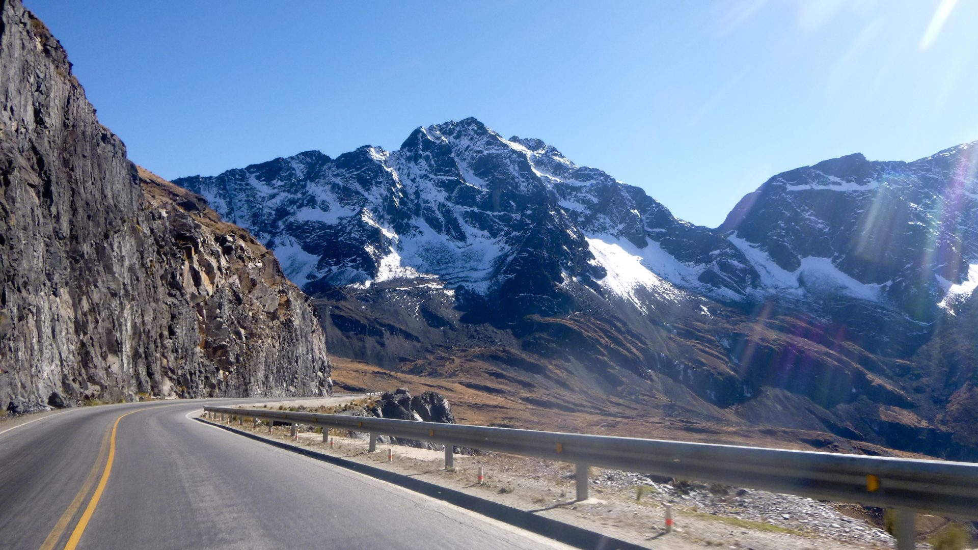 Sommets enneigés des Andes dominant la route au départ de la descente, Altiplano bolivien