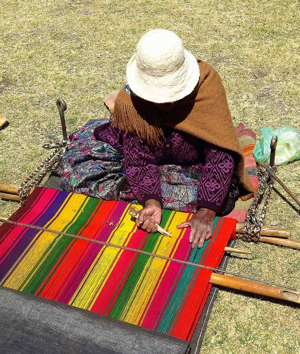 Tisseuse aymara de Santiago de Okola réalisant un textile andin traditionnel au bord du lac Titicaca
